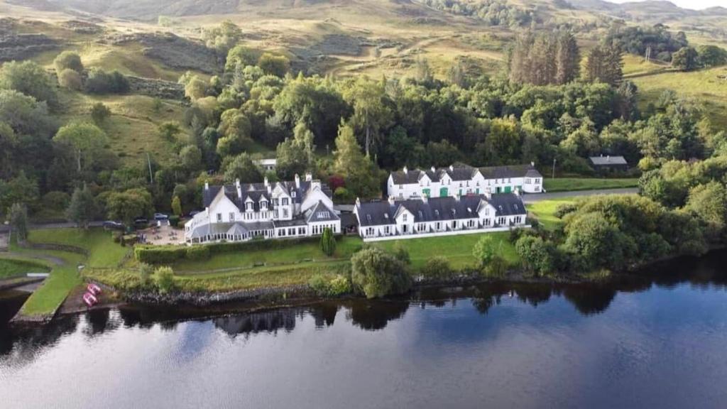 an aerial view of a large house on an island in a lake at Loch side Apartment, Inveraray in Portsonachan