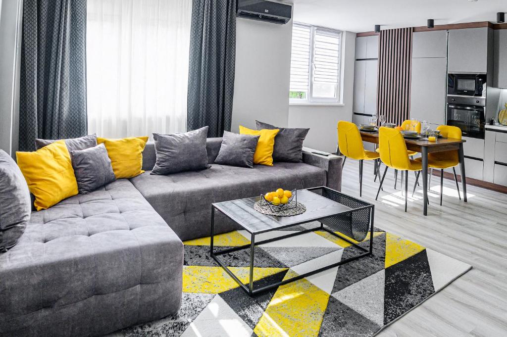 ein Wohnzimmer mit einem grauen Sofa und gelben Kissen in der Unterkunft Cozy and Stylish Apartment 2 in Stara Sagora