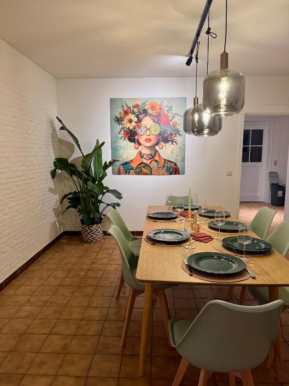 a dining room with a wooden table and green chairs at Villa Oni met grote speelruimte in Koksijde