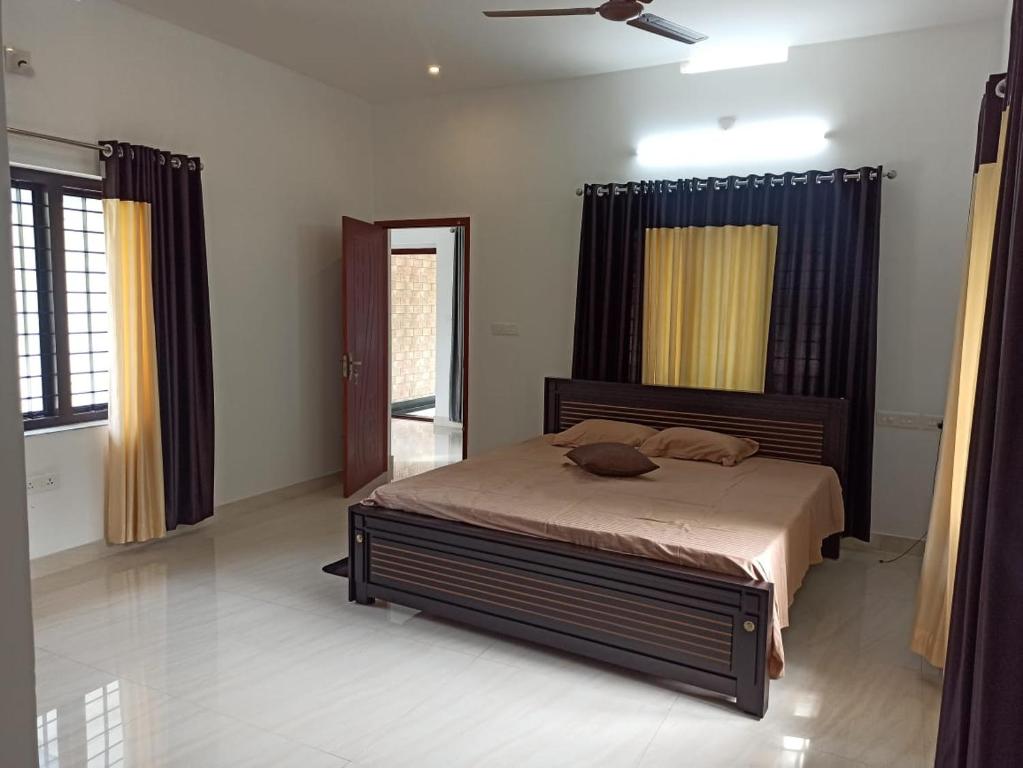 a bedroom with a bed and a ceiling fan at Liyano homestay in Palakkad