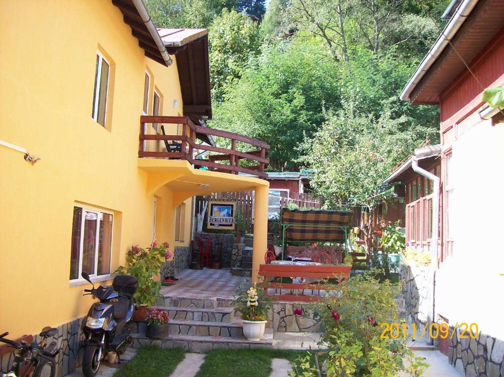 a house with a porch with a bench and a balcony at Casa Valea Cerbului Busteni in Buşteni