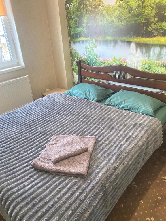 a bed with two towels sitting on top of it at Міні готель & хостел Шервуд in Zhytomyr