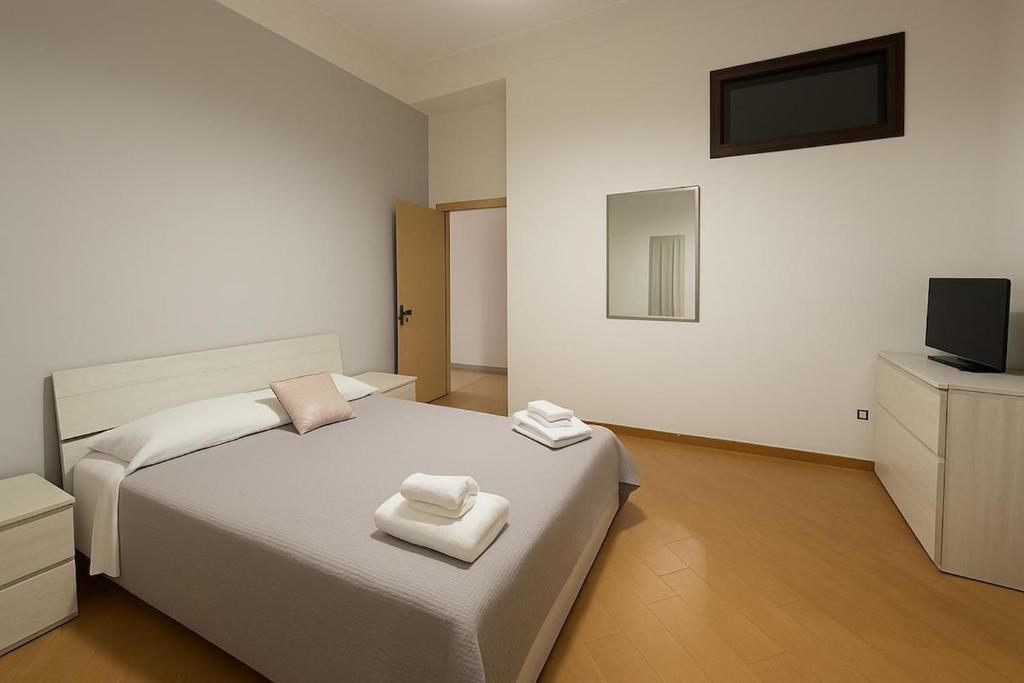 una camera da letto con un letto bianco e una televisione di House by the station -Close to Oplonti Ruins a Torre Annunziata