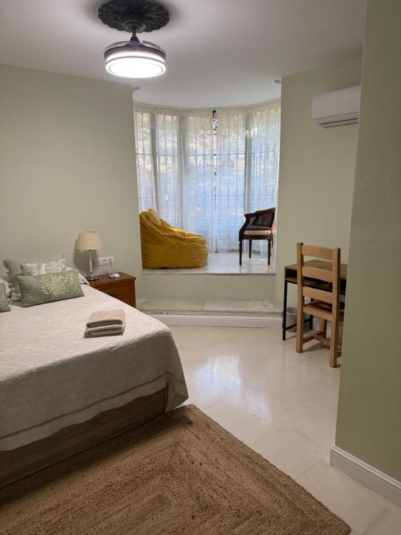 a bedroom with a bed and a table and a window at Bronlara in Alhaurín de la Torre