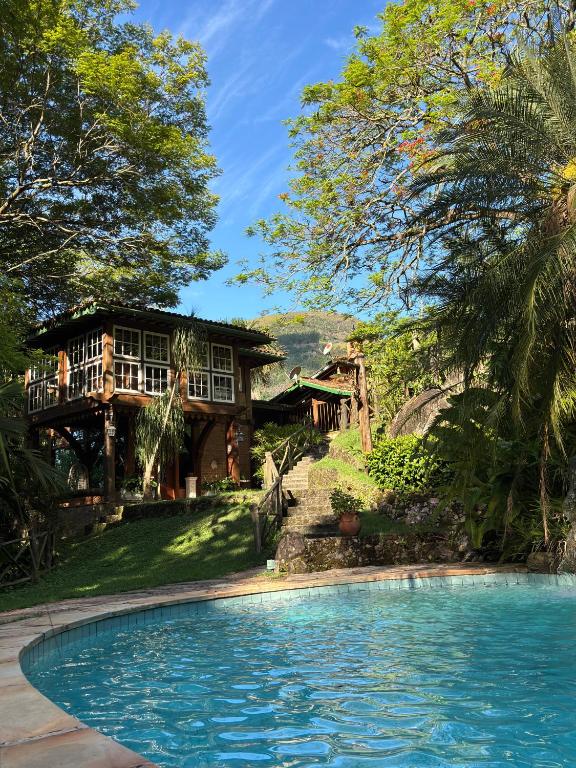 a house with a swimming pool in front of a house at Guest House Tânia Alves in Pratinha