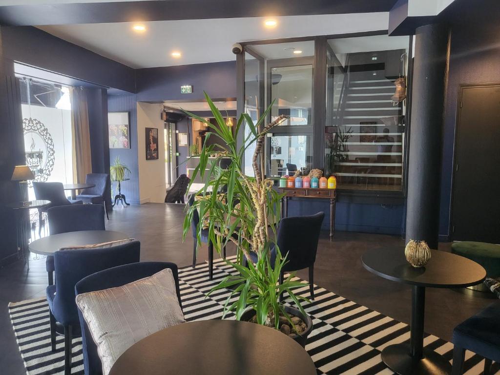 a restaurant with tables and chairs and a plant at Le Patio De La Dordogne in Souillac