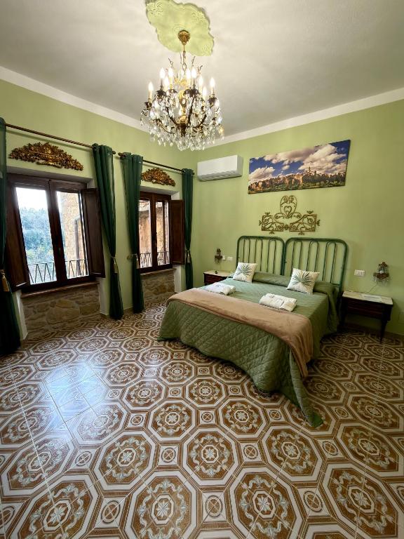 a bedroom with a bed and a chandelier at Casa del Ghetto in Pitigliano