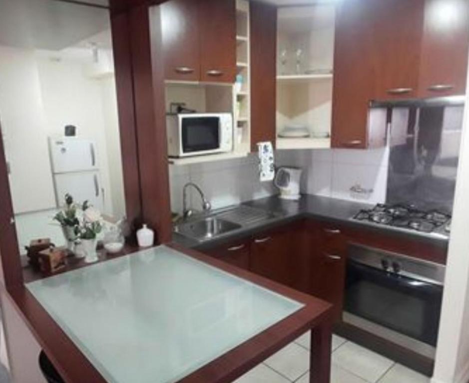 a kitchen with wooden cabinets and a counter top at Concepto HD Merced in Santiago