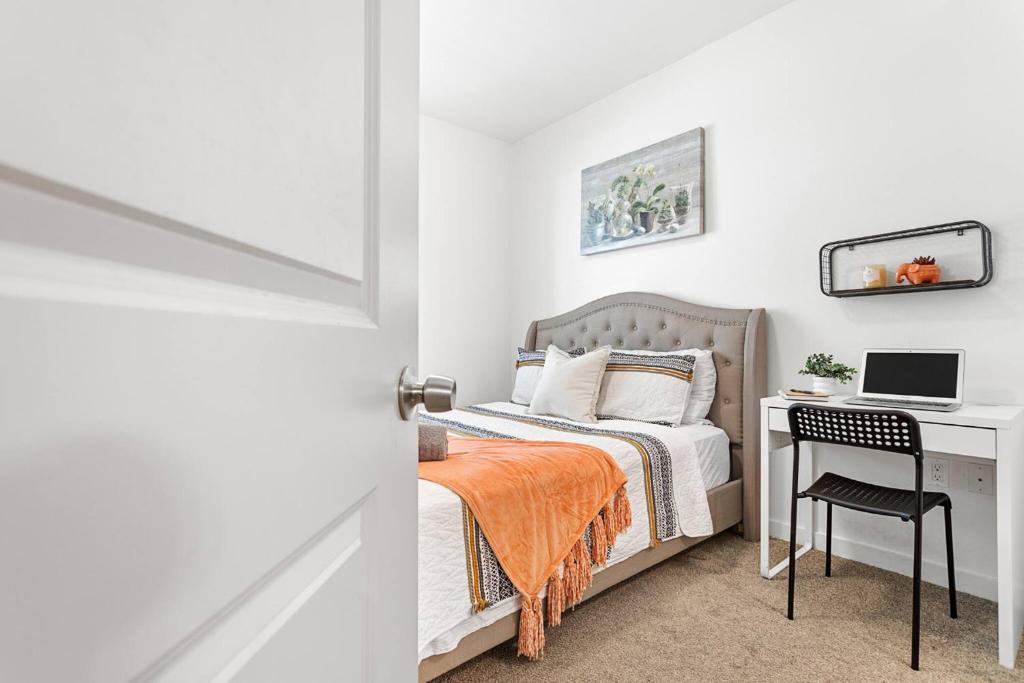 a bedroom with a bed and a desk with a laptop at Modern Room Nested In The Heart Of Orange County in Tustin
