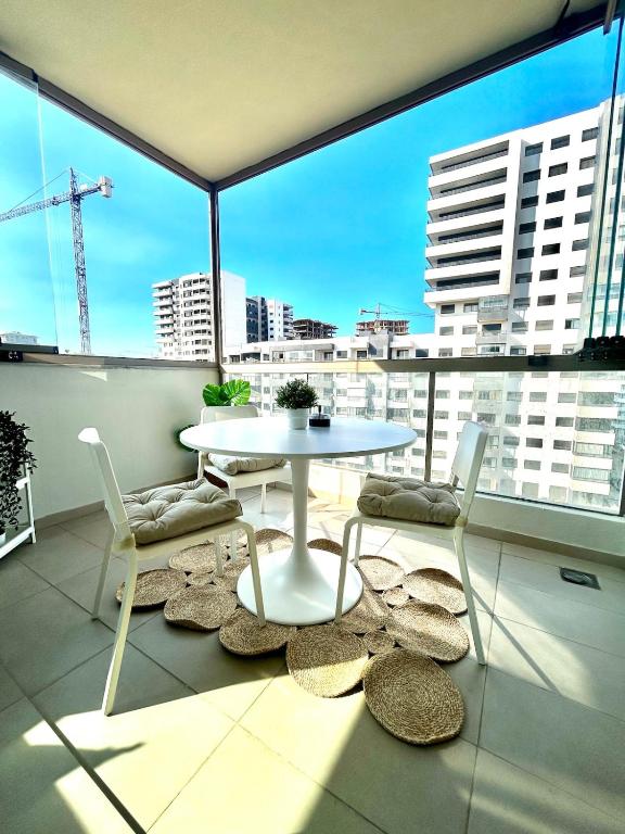 a table and chairs on a balcony with a view of a city at Luxury Studio in a secured residence in Aïn Harrouda