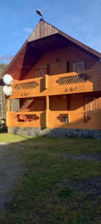 ein großes Holzgebäude mit einem Walmdach in der Unterkunft Edelveys in Worochta