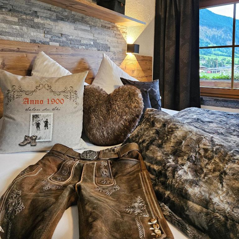 a bed with a blanket and pillows on it at Luxus Apartment Nina mit Zirbenhütte in Ramsau im Zillertal