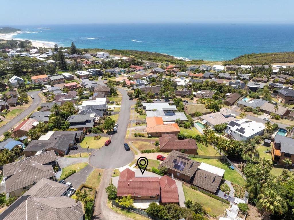 an aerial view of a town with houses and the ocean at Oceans 21 Caves Beach in Caves Beach