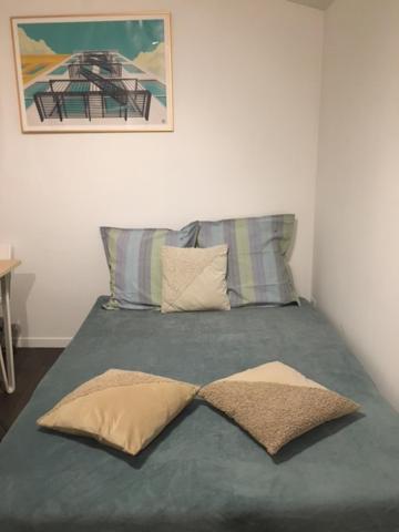 una cama con dos almohadas encima en Studio Eysines, en Eysines