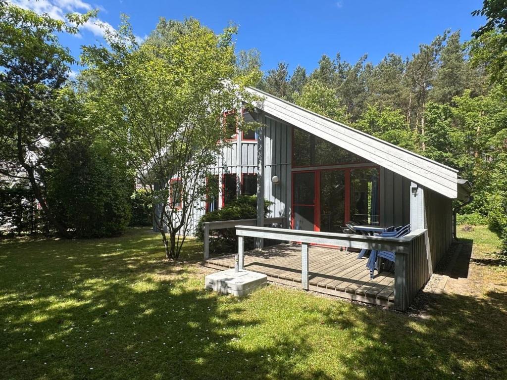 a small cabin with a deck in a yard at exklusives skandinavisches Ferienhaus in Granzow
