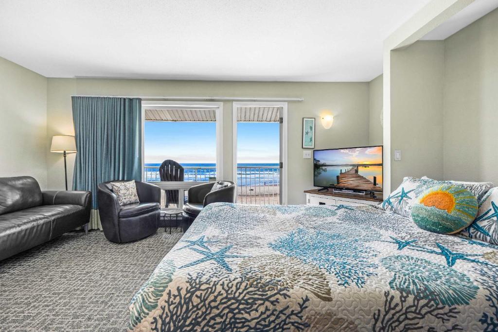 a hotel room with a bed and a view of the ocean at Oceanfront Family Suite - Full Kitchen - Beach Access - Pool & Hot Tub in Lincoln City