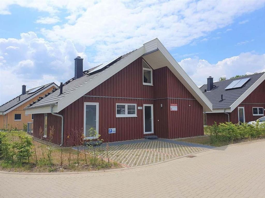 een rode schuur met zonnepanelen erop bij exklusives skandinavisches Ferienhaus in Granzow