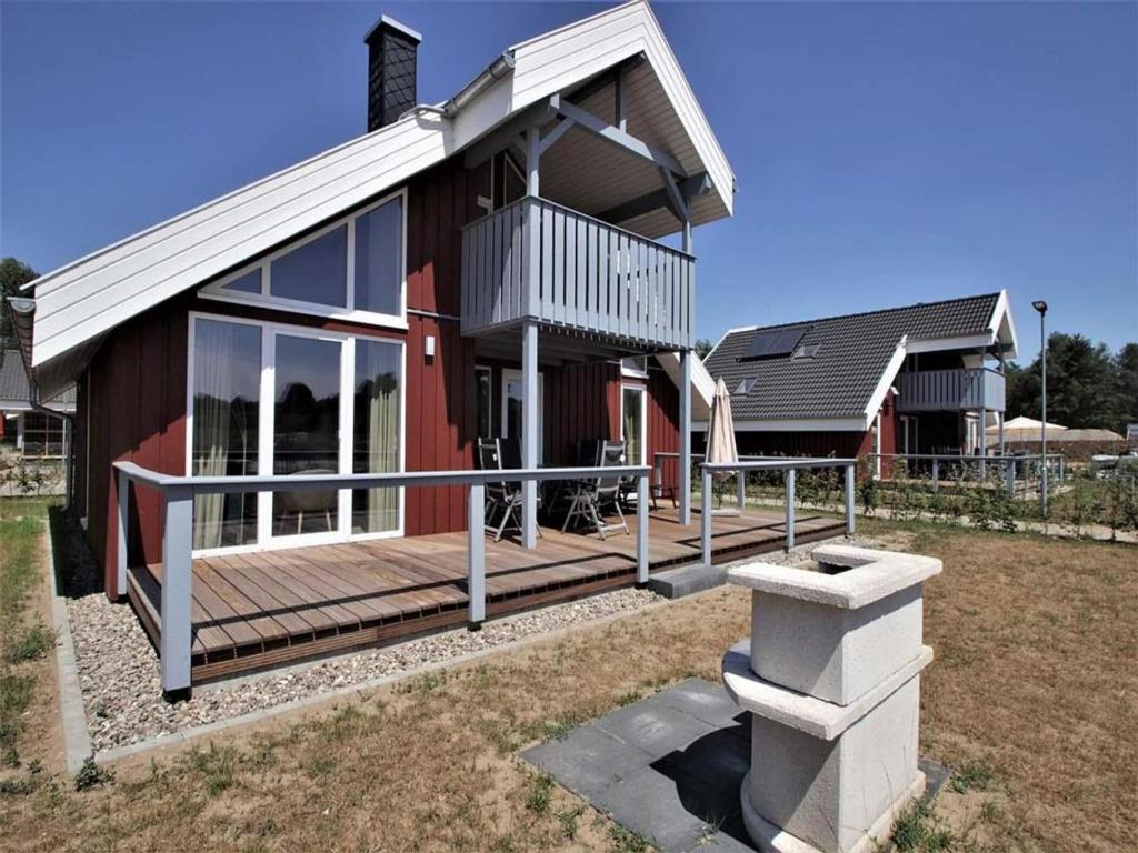 een huis met een groot houten terras in een tuin bij Ferienhaus im skandinavischen Stil in Granzow