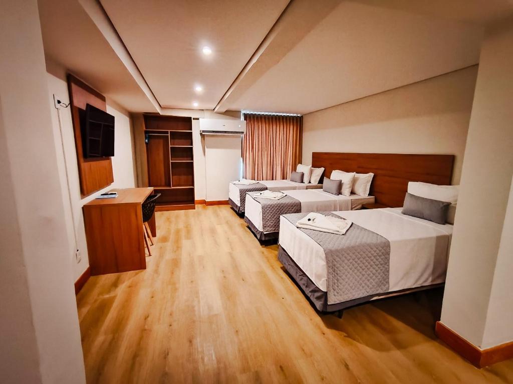 a hotel room with two beds and a desk at Amazon Seasons hotel in Belém