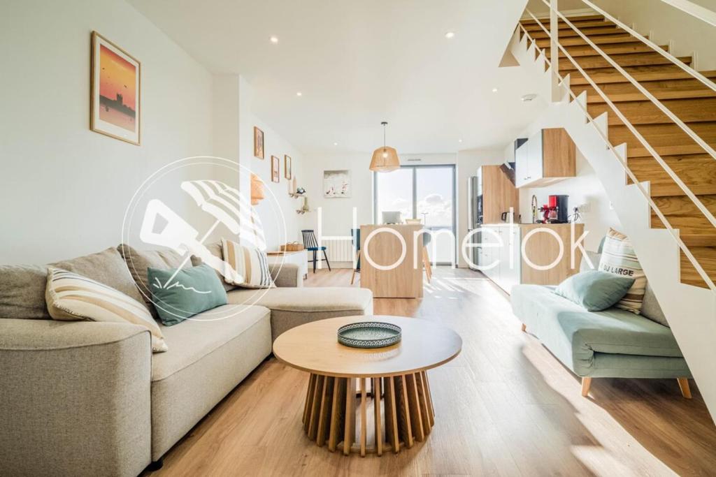 a living room with a couch and a table at Duplex d Exception Vue sur le port de Quiberon in Quiberon