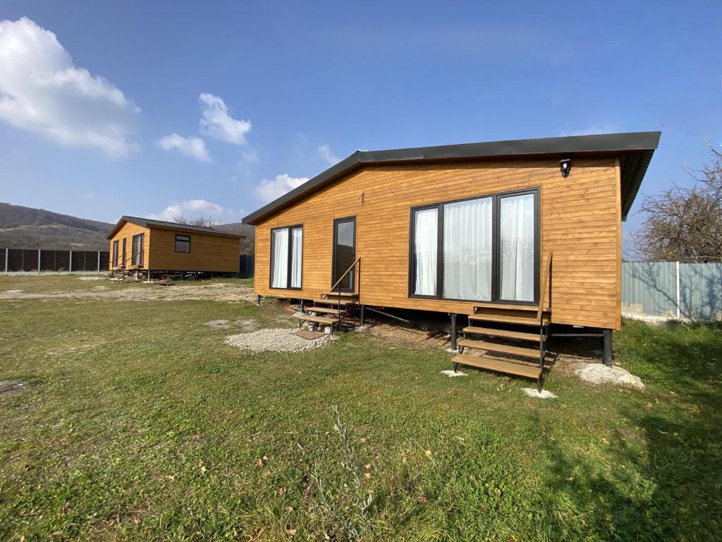 a small wooden house in a field of grass at Tianeti Apple Cottages 