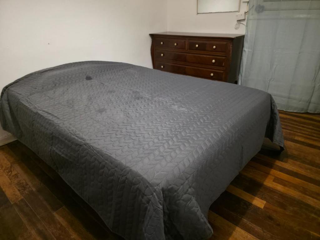 a bed with a gray comforter in a bedroom at Habitación zabalburu D&S in Bilbao