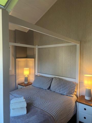 a bedroom with a bed with two lamps and towels at The Annex Apartment is on Cheddar Bridge Apartments in Cheddar