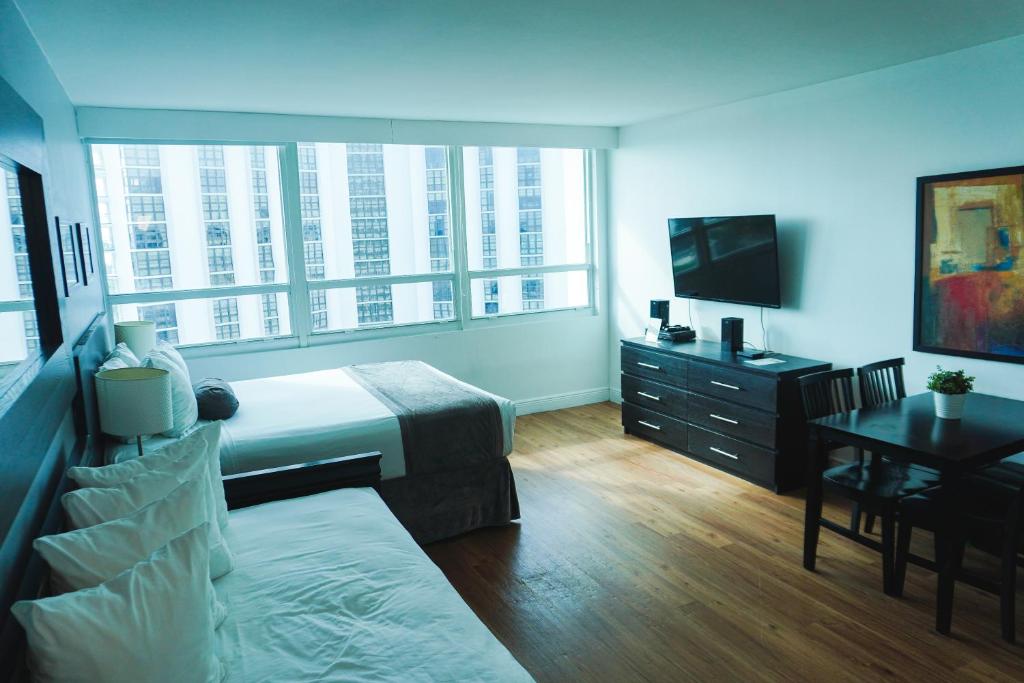 une chambre avec un lit, un bureau et une télévision dans l'établissement Shine Suites Studio 11, à Miami Beach