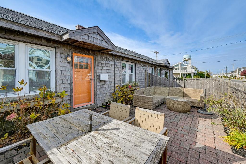 a patio with a wooden table and chairs in front of a house at Walk to Beach and Dtwn Dining! Avalon Coastal Escape in Avalon