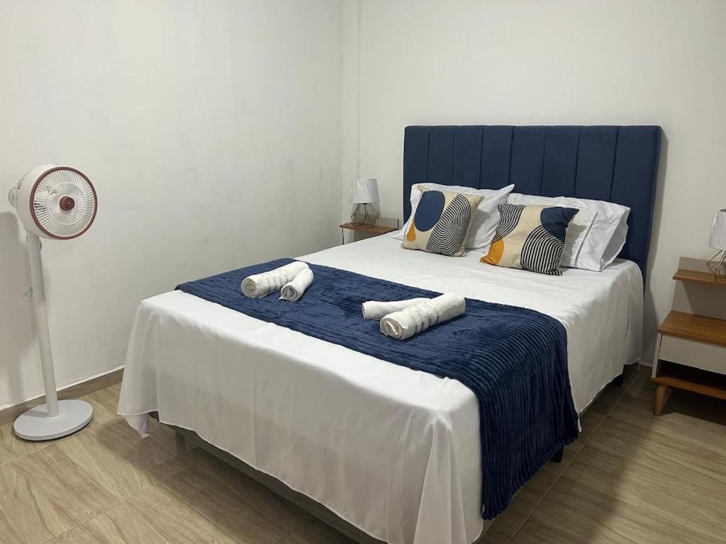 Un dormitorio con una cama grande con toallas. en Entre Mar e Morros, Apto praia Pontal Recreio, en Río de Janeiro