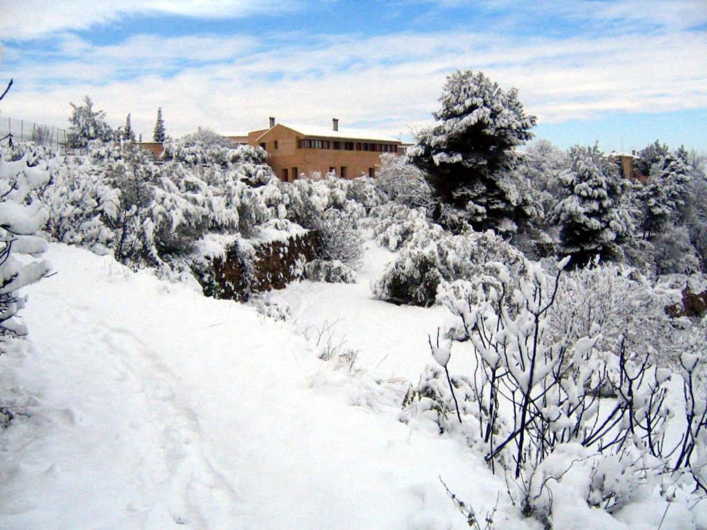 a snow covered road in front of a house at Casas Rurales El Parador in Letur