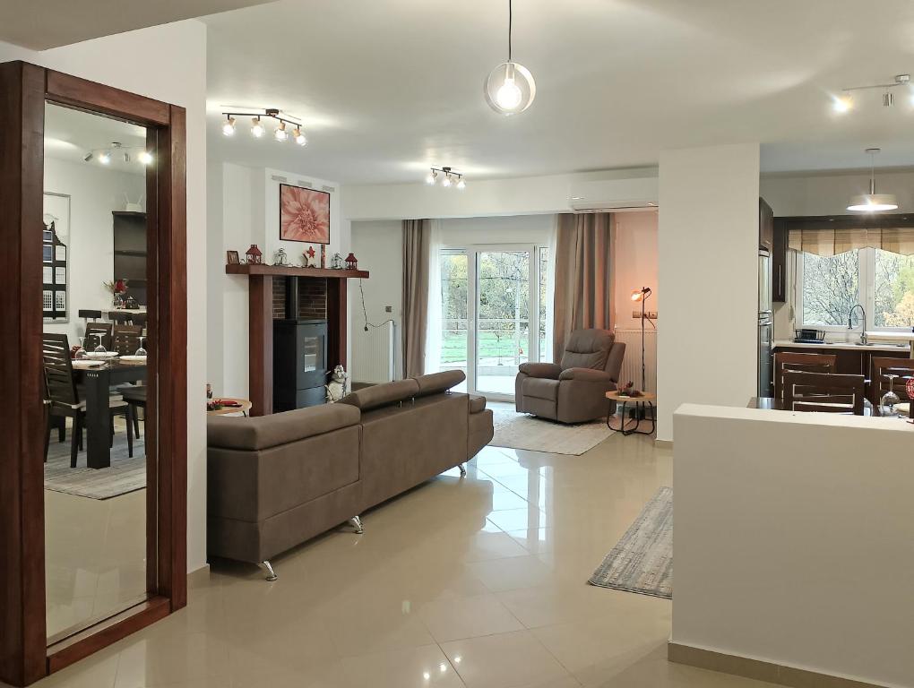 a living room with a couch and a dining room at Chloe Maxi Apt 108 sqm in Kastoria