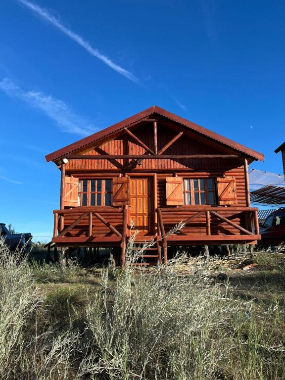 una casa in legno con tetto su un campo di Olivillos II a Balneario Pehuén-Có