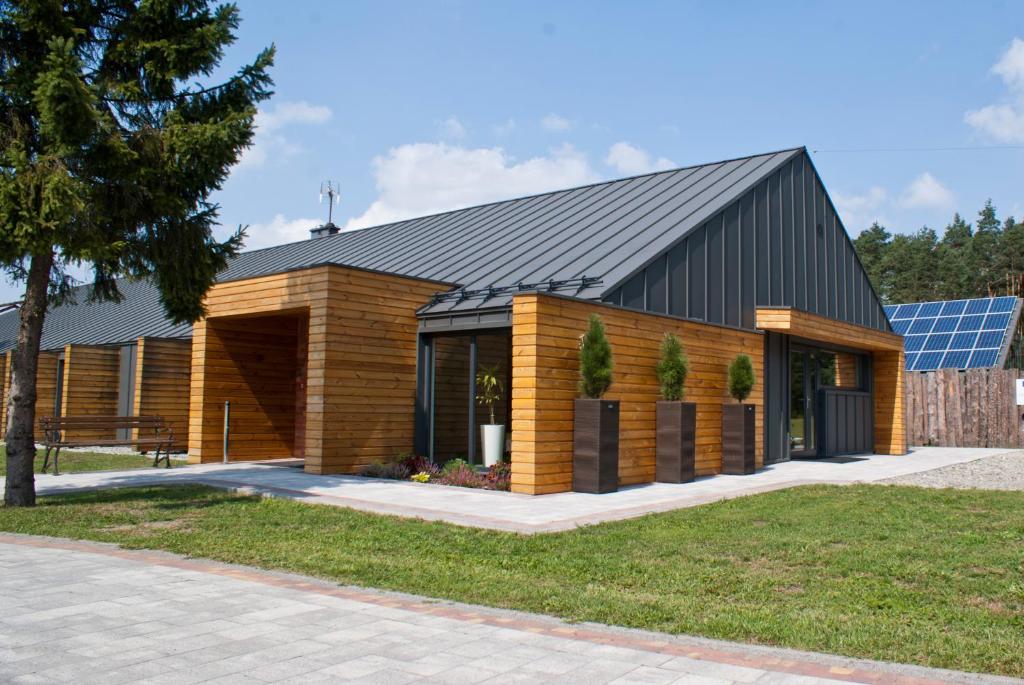 een modern huis met een zwart dak en hout bij Kompleks Taaka Ryba in Sumina