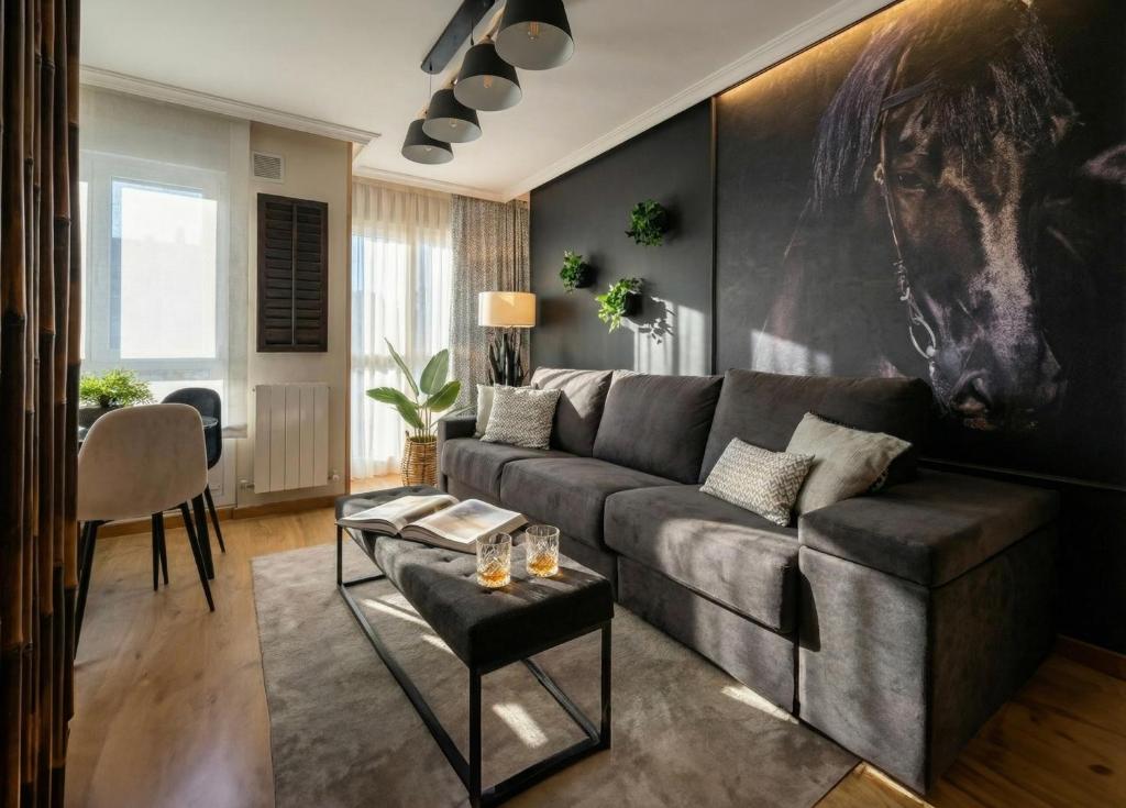 un soggiorno con un divano e un tavolo di El Balconcillo - Boutique premium en pleno Gijón - Grupo Querbes a Gijón