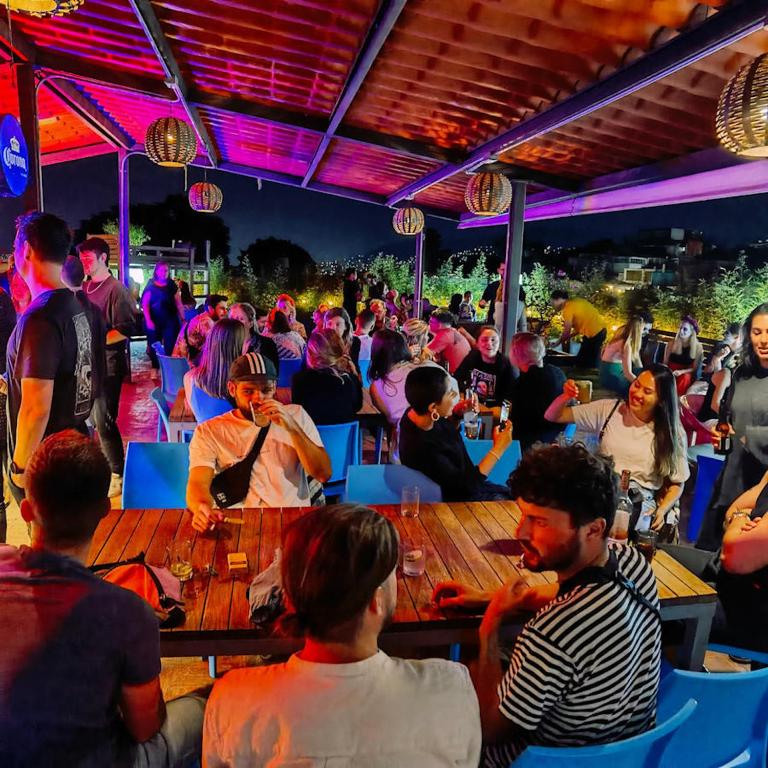 a crowd of people sitting at tables in a bar at Casa Angel Hostel in Oaxaca City
