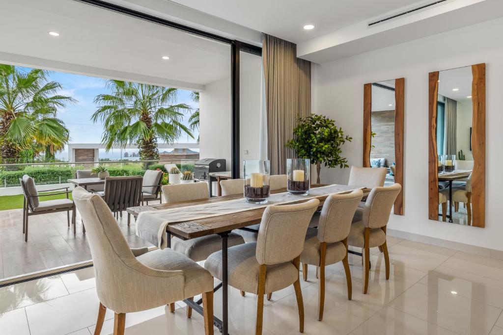 a dining room with a table and chairs at Modern Condo with Stunning Bay Views in Cabo San Lucas