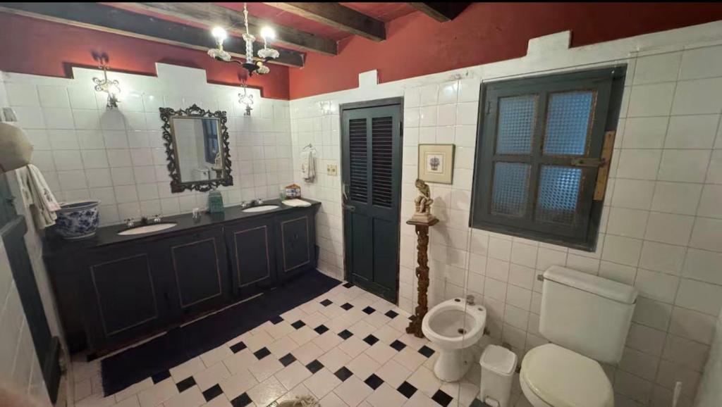 un baño con inodoro y lavabo en Habitación para 4 en el centro de Asunción con piscina e inmenso jardín, en Asunción