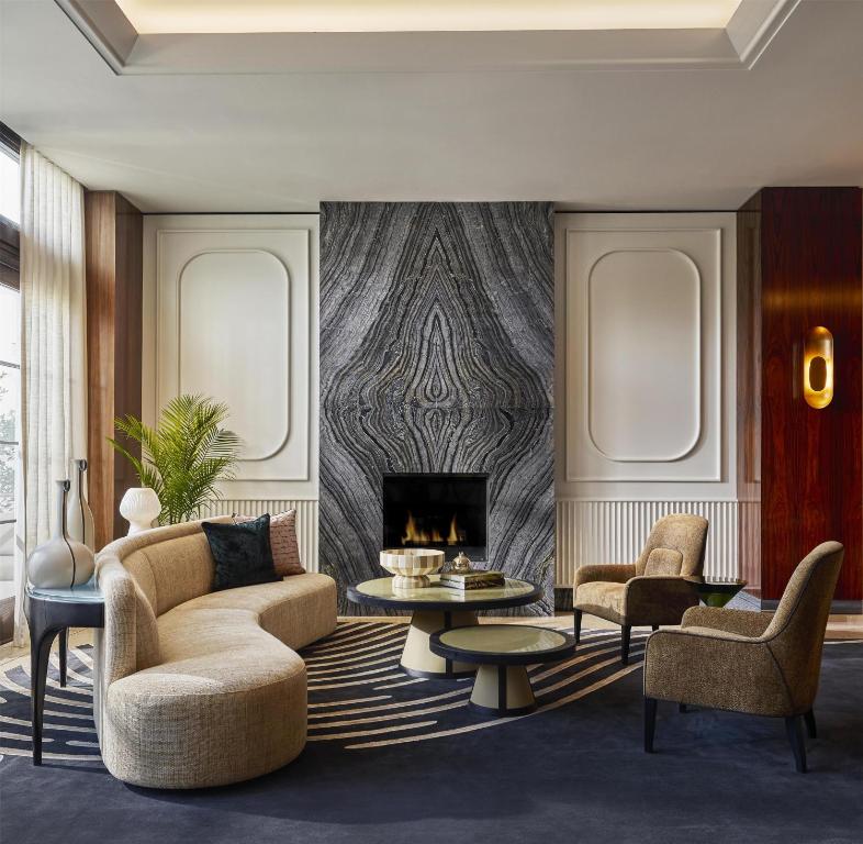 sala de estar con sofá, sillas y chimenea en Cameo Beverly Hills, LXR Hotels & Resorts, en Los Ángeles