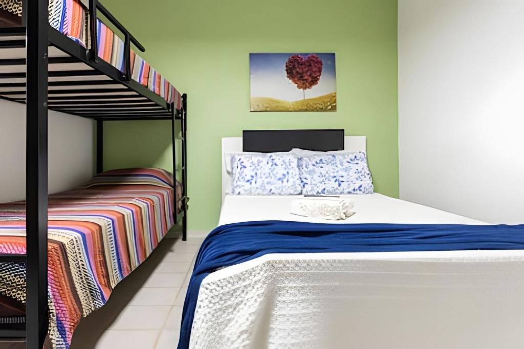 ein Schlafzimmer mit einem Etagenbett neben einem Etagenbett, einem gmaxwell gmaxwell gmaxwell in der Unterkunft Casinha p/5 Charmosa in Volta Redonda