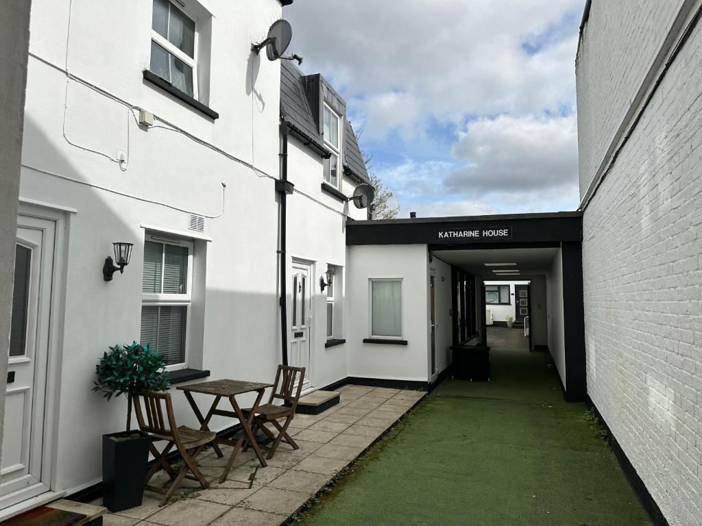 an alleyway between two buildings with a table and chairs at One bed Mews House in Northwood