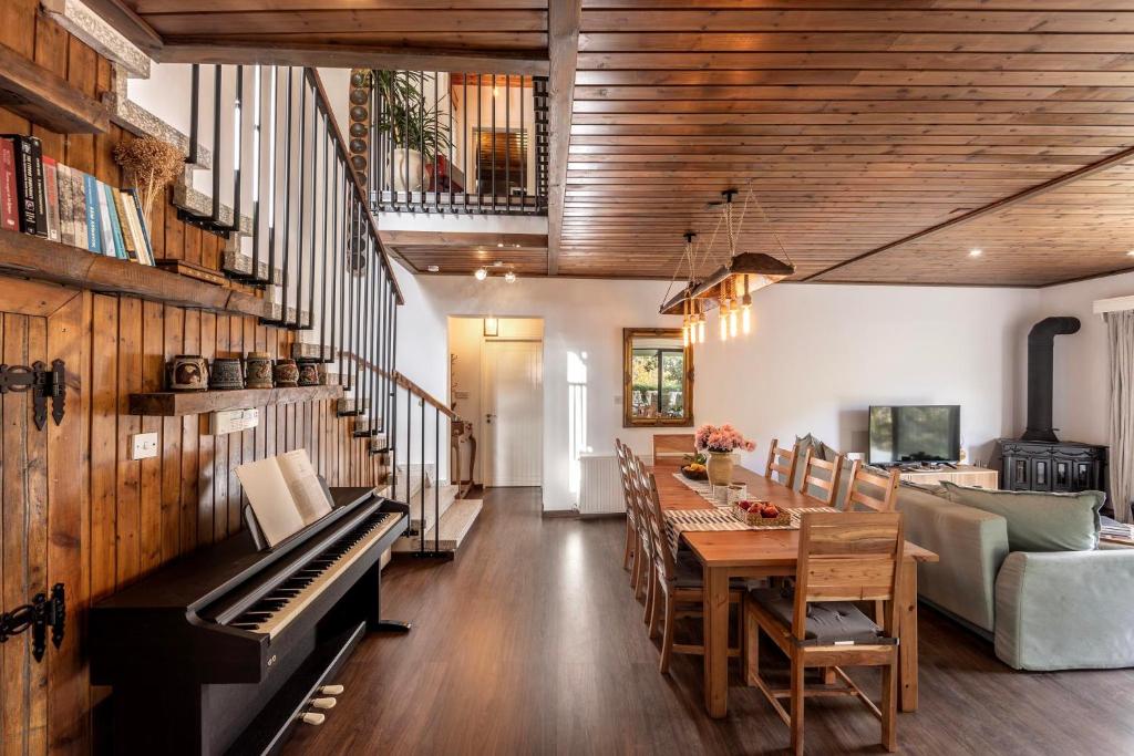 a living room with a piano and a dining room at Maison du Mont in Kalopanayiotis