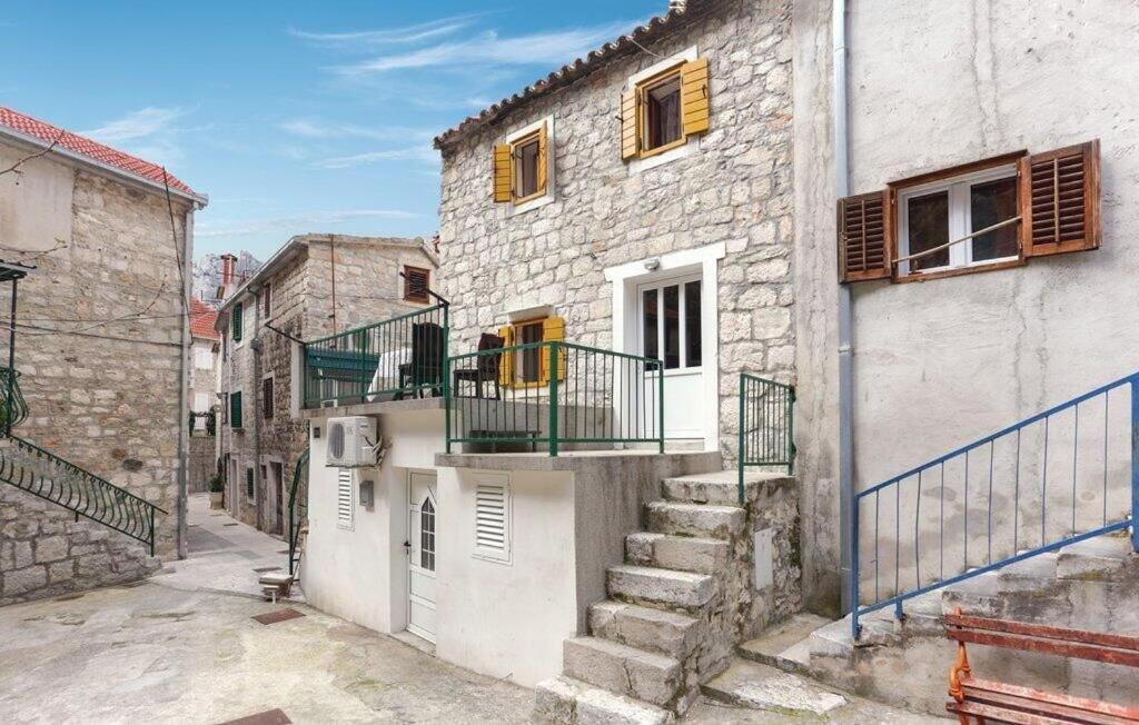 a stone building with stairs and a balcony at Apartment Protrka in Omiš