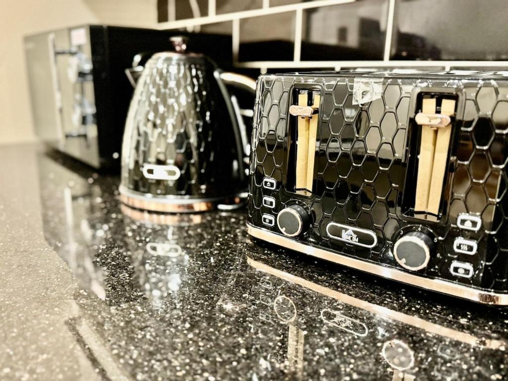 a black toaster sitting on top of a counter at Spacious 5-Bed House in Chigwell - Grange Hill in Chigwell