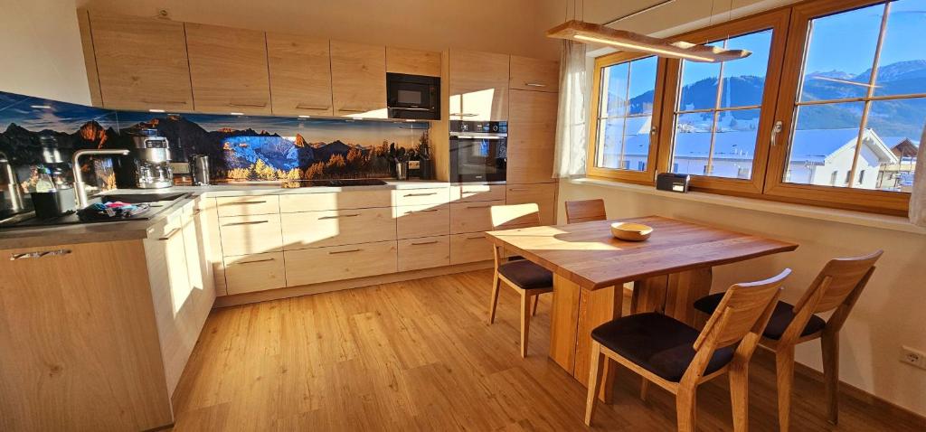 eine Küche mit einem Holztisch und einem Tisch und Stühlen in der Unterkunft Ferienwohnungen Hipp - Bergblick und Wellness in Top Lage in Halblech