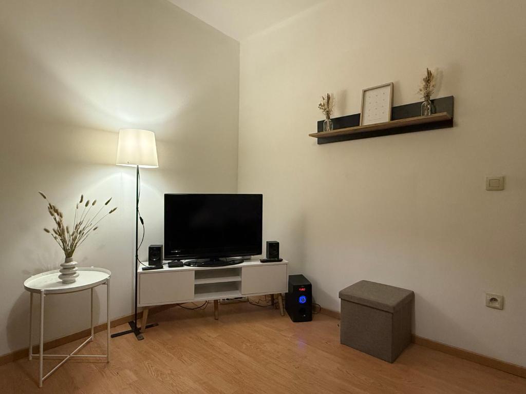uma sala de estar com televisão numa secretária branca em Duplexe Cosy - HERSTAL em Herstal