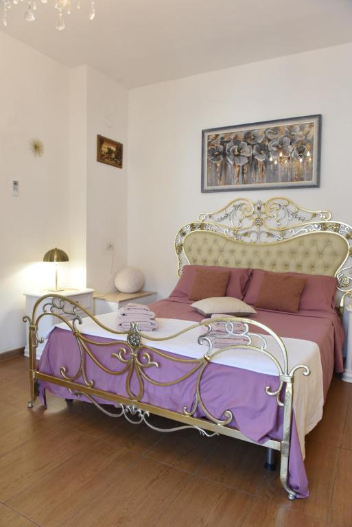 a bedroom with a bed with a purple and white bedspread at La perla di Caserta 2 in Caserta