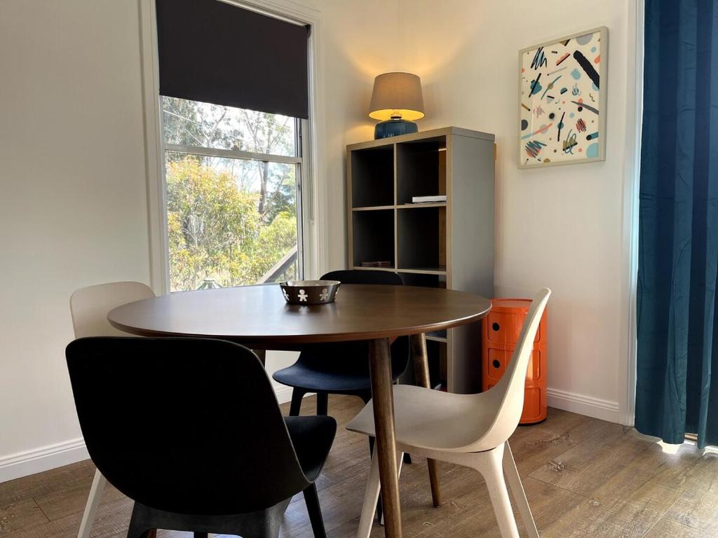 a dining room with a table and chairs and a window at Happy Mountain House in Blackheath