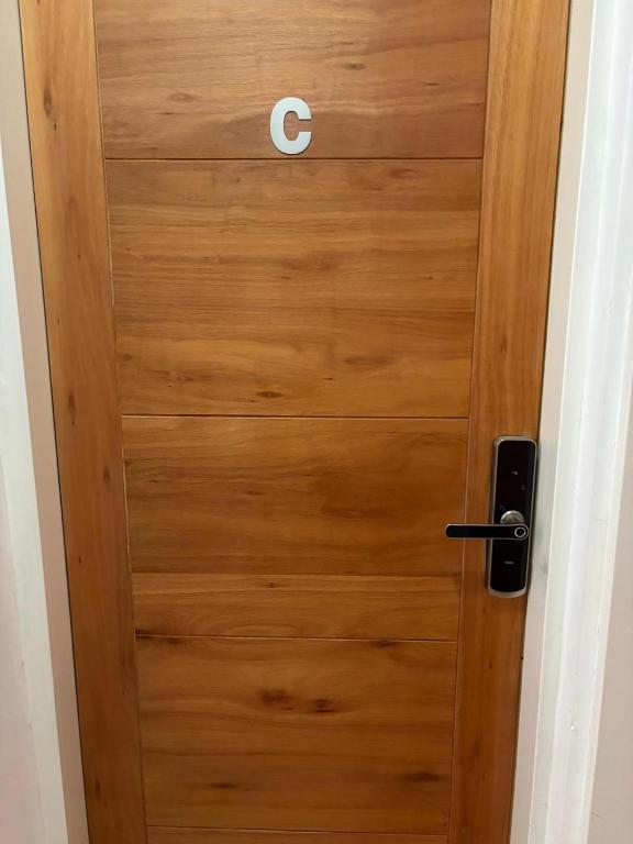 a wooden door with the letter c on it at Departamento Liban in San Juan