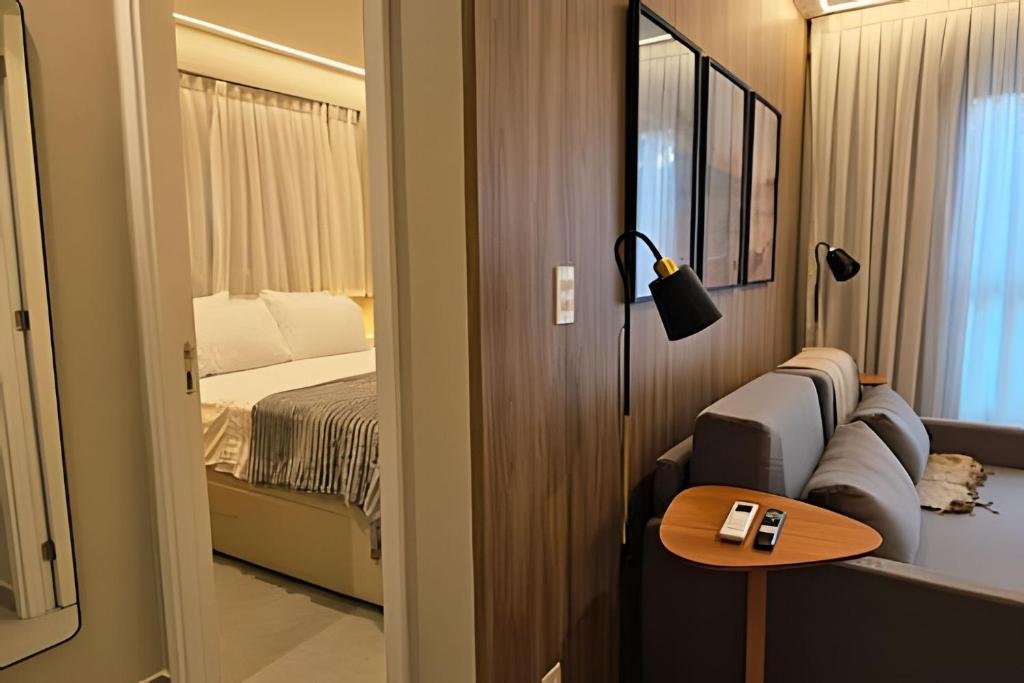 een slaapkamer met een bed en een tafel met een lamp bij NOVO e Impecável • 1 Quarto • pertinho do LETREIRO in Tambaú